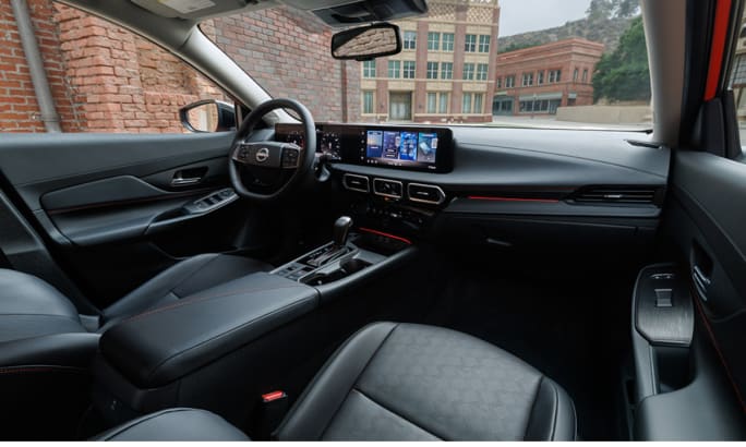View of the 2026 Nissan Sentra’s cabin, featuring the steering wheel, center console, and dual digital displays on the dashboard.