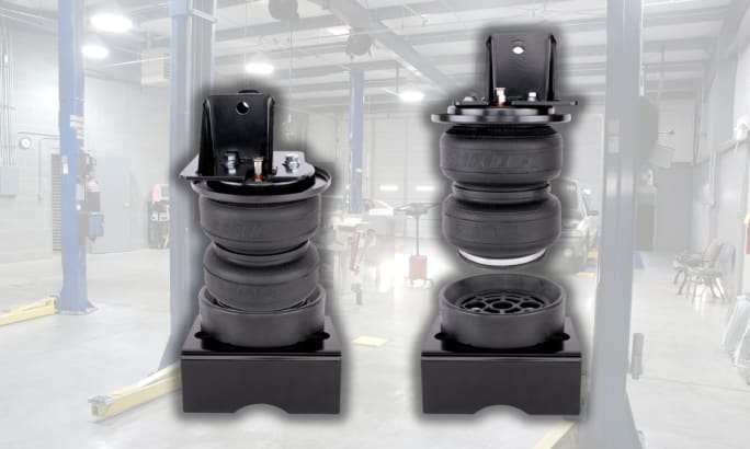 Two Air Lift LoadLifter 5000 Ultimate suspension components displayed in a service bay.