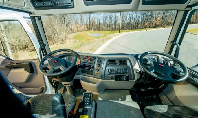 Front view of a Peterbilt Model 220 truck parked on a road, modified by Fontaine Modification with dual-drive steering capability.