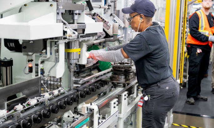 Toyota Alabama employee using automated machinery during differential assembly process in Huntsville plant.