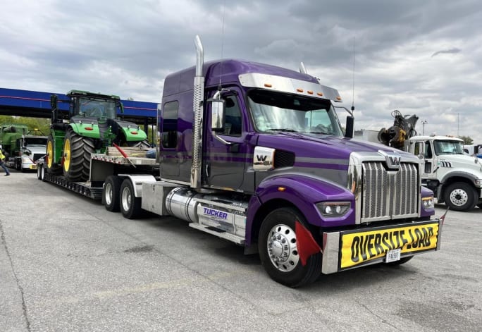 Tucker Freight Lines purple truck with dropdeck trailer