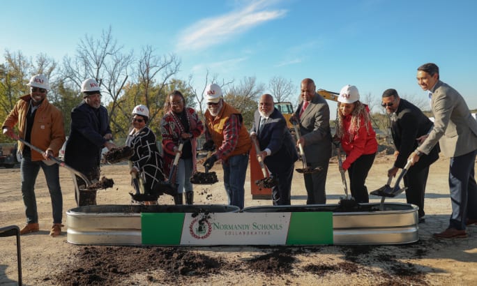 Group of officials and partners participating in a groundbreaking event for Normandy Schools Collaborative’s electric school bus project.