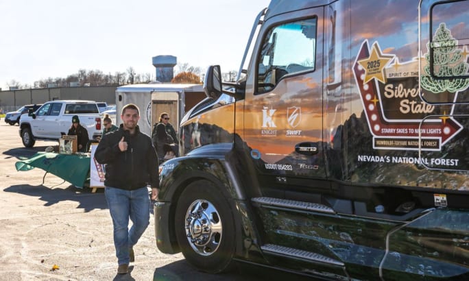 Michael Porter stands beside a Kenworth T680 with U.S. Capitol Christmas Tree tour graphics during a community event stop.