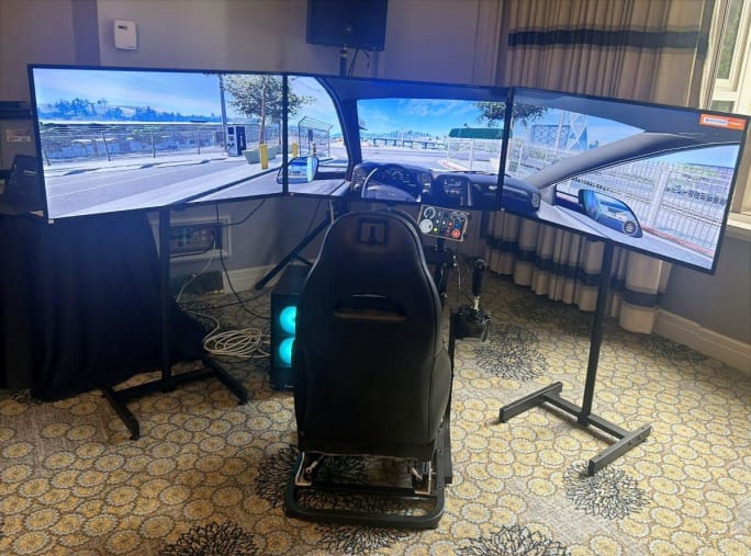truck driver seat sitting in front of three large computer screens