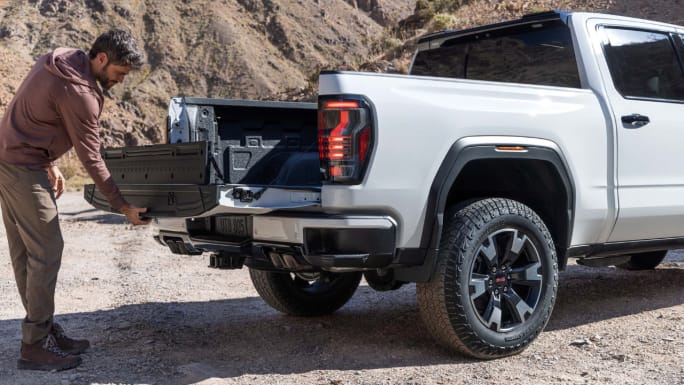 Rear shot of the 2027 GMC Sierra 1500 AT4 in Coastal Dune driving offroad. Preproduction model shown. Actual production model may vary.