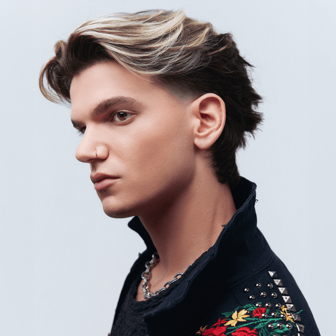 a man with a blonde and black swooping haircut