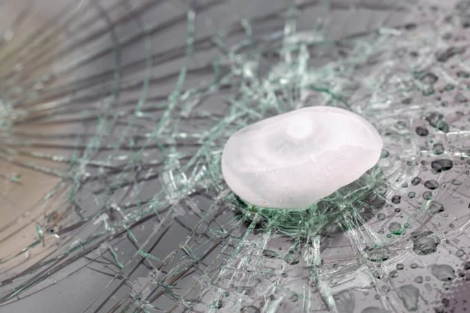 A Shattered Windshield caused by a large hailstone illustrating the kind of storm damage that can trigger insurance claims and require urgent glass repair for fleet vehicles