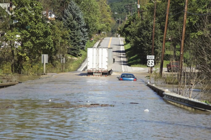 Flash-flooded highway with vehicles driving through high water after a severe storm