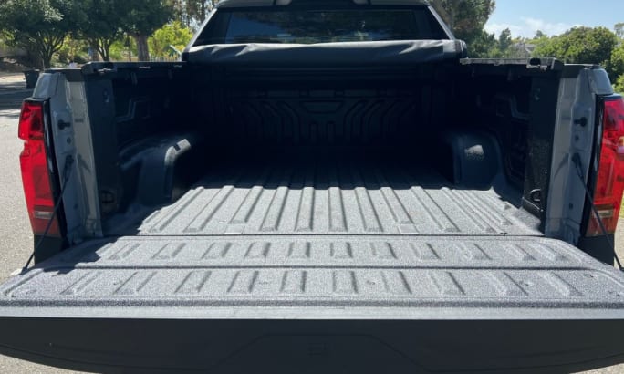 A rear view of the Silverado cargo bed with the tailgate lowered and tonneau cover rolled up.