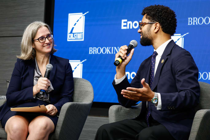 Rebecca Higgins and The Hon. Maxwell Frost speak on stage.