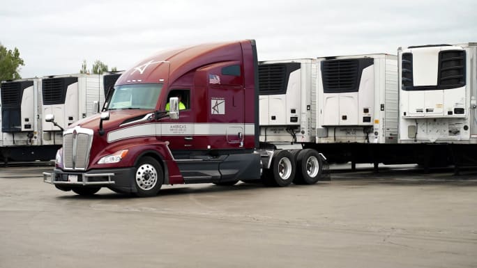 Photo of maroon ASL tractor backing in to pick up a refrigerated trailer