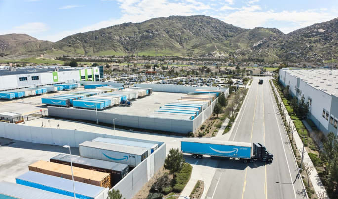 Amazon tractor-trailer pulling out from between warehouses shot from above