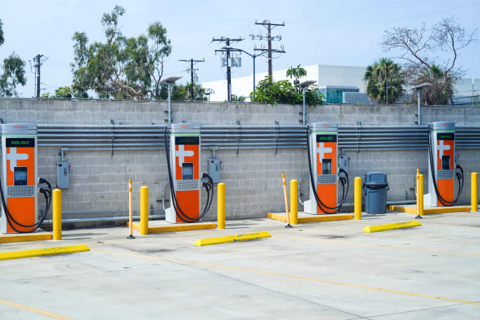 Charging infrastructure in front of a concrete wall.