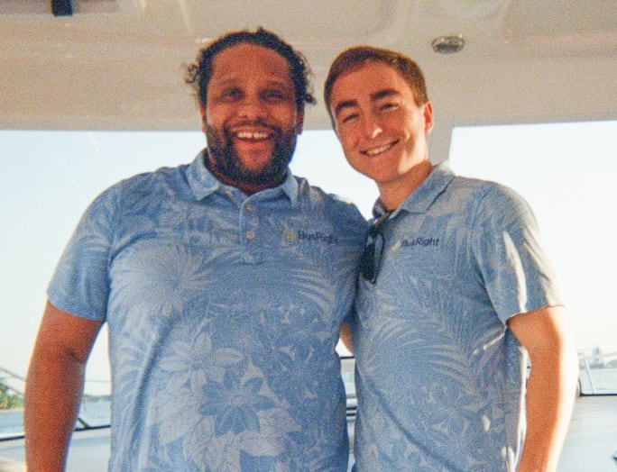 two men stand next to each other in blue polo busright shirts