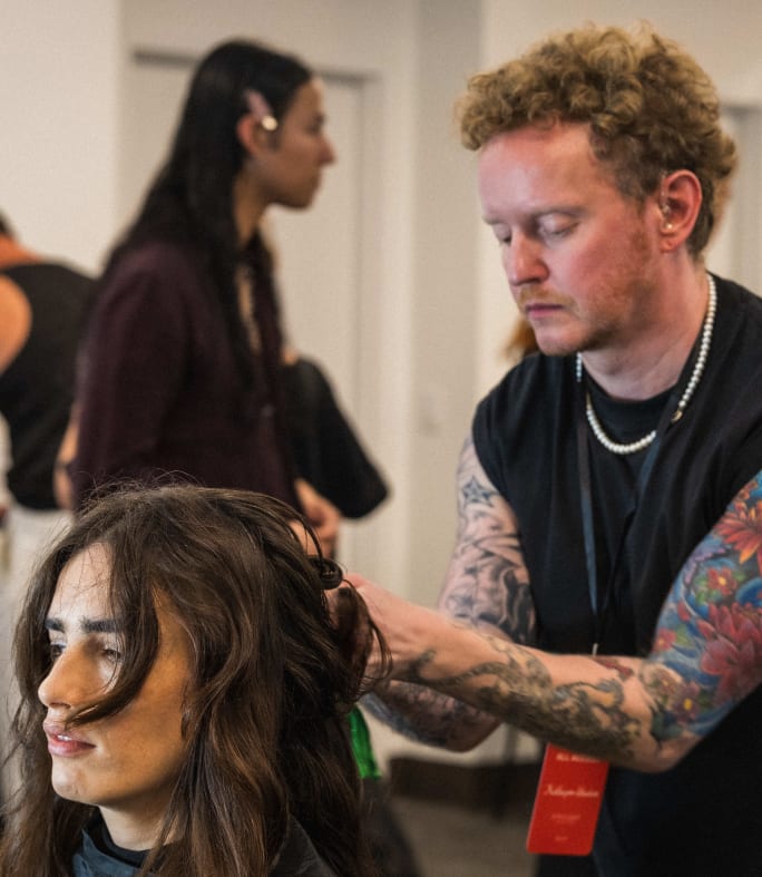 man doing a runway model's hair