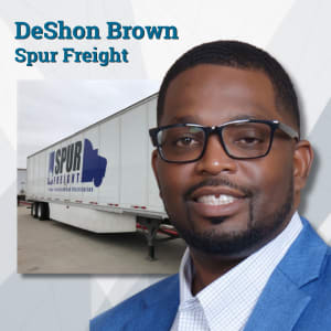 Black man with glasses with Spur Freight trailer in the background