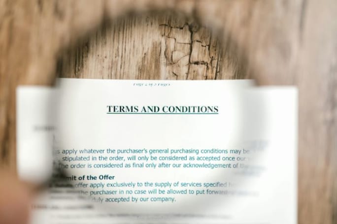 Photo of a Terms and Conditions document seen through a magnifying glass