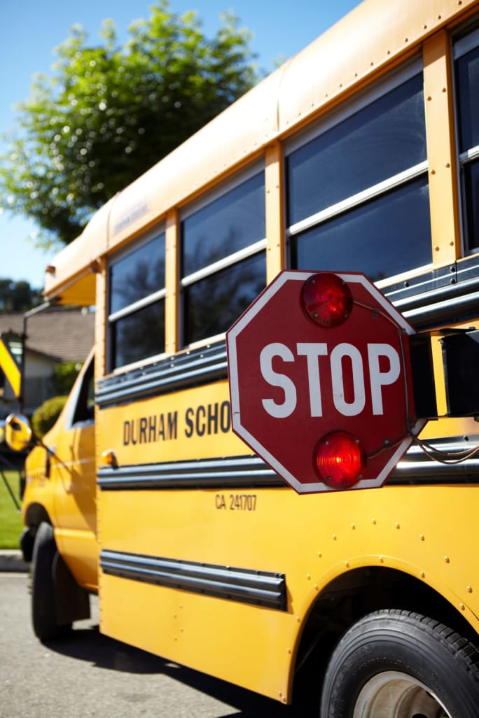 A Durham School Services school bus with the stop-arm extended.