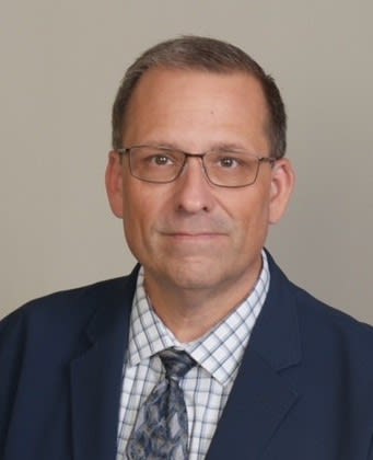 Headshot of James Kennard in blue suit