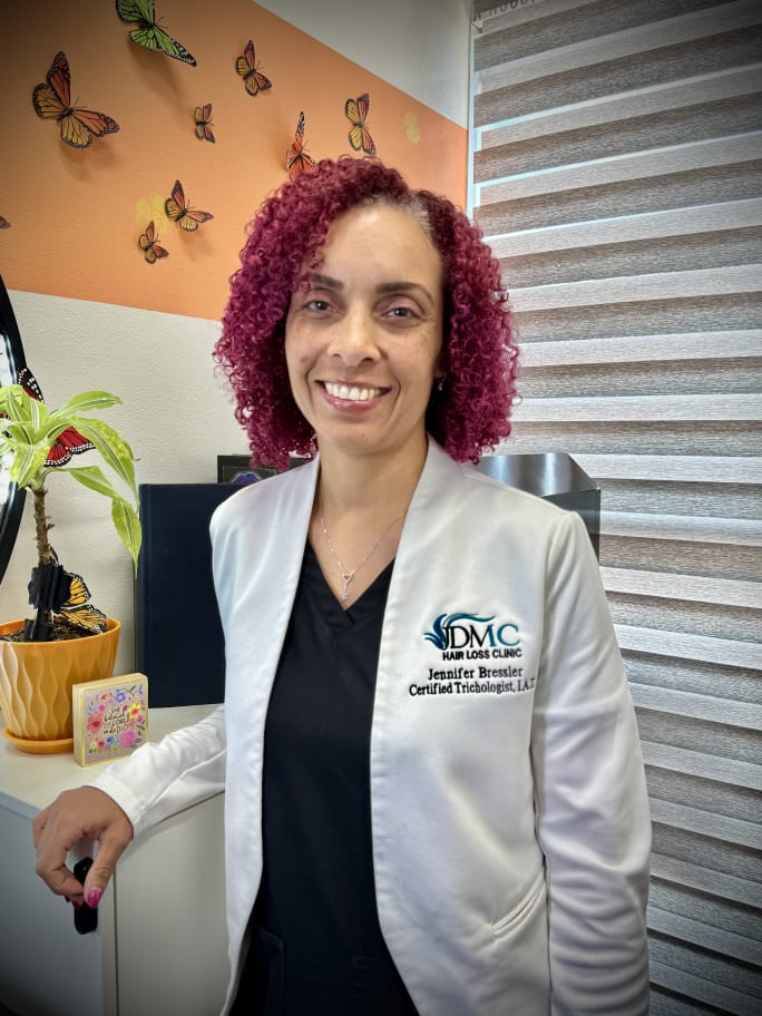 A woman wearing a lab coat, and she has curly red hair.