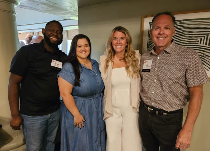 three people stand together during a happy hour