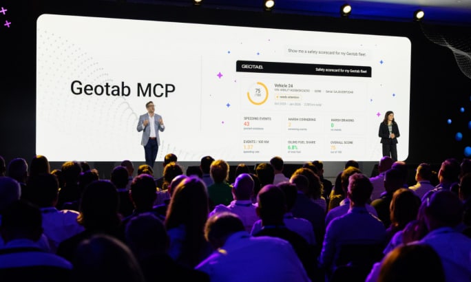 Geotab professionals standing on a stage in front of a crowd.