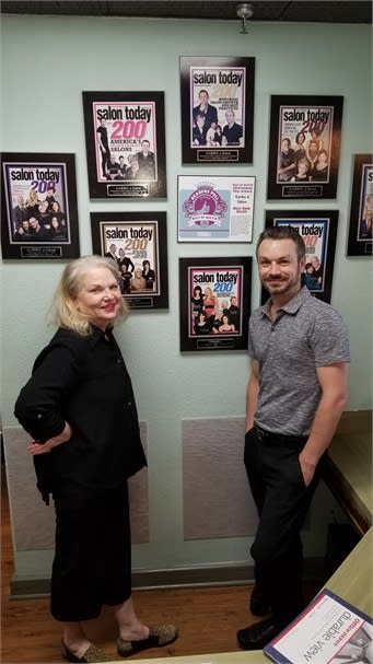 Marsha Power, owner of Garbo A Salon and Spa in Austin, Texas, and Jonathon Jones, executive director in front of the salon's wall of fame.