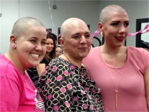 At Tricoci University of Beauty Culture in Chicago, student Jennifer Clark, left, and Campus Director Kate Sampson, right, showed their solidarity with Kellie Diaz by having their heads shaved during a fundraiser for Diaz's medical expenses.