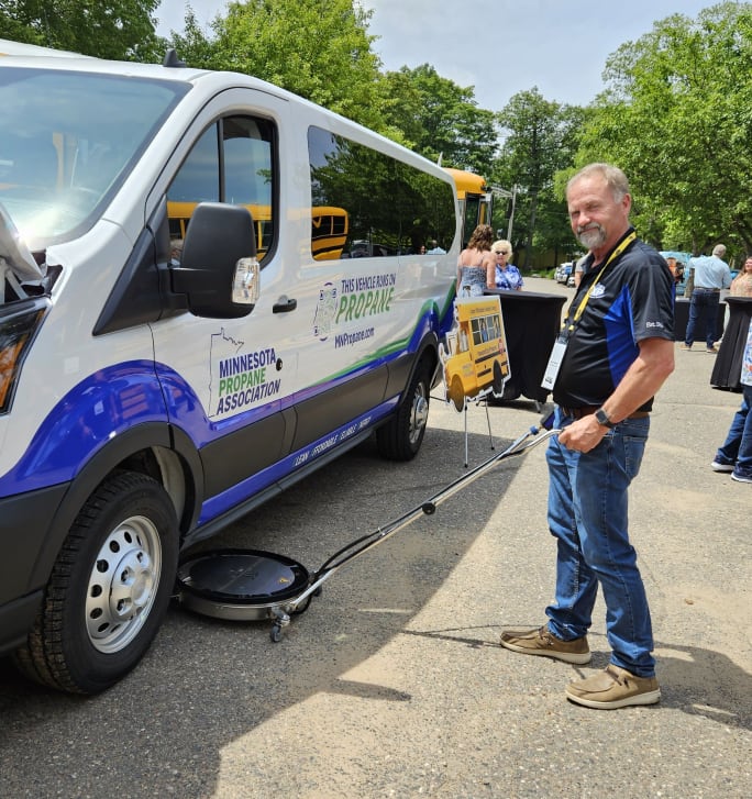 a man demonstrates a bus undercarriage pressure washer