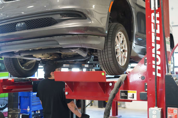 A car on a lift in the auto shop.