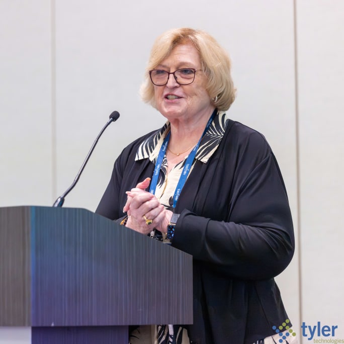 Molly McGee-Hewitt, executive director of the National Association for Pupil Transportation (NAPT), speaks from the podium during a general session at the 2026 NSTA Annual Meeting & Convention in Denver, addressing attendees on issues affecting the student transportation industry.