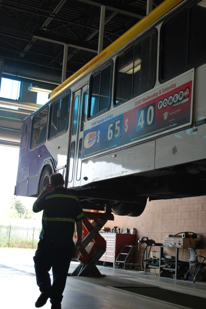 Worker underneath bus