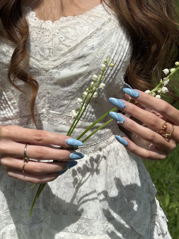 A closeup shot on a young woman's hands and blue nails