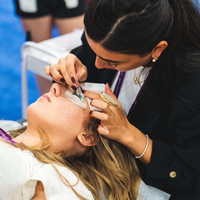 An esthetician applies false lashes