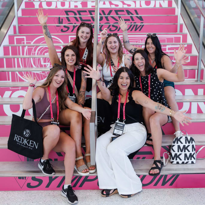a group of women sitting on pink stairs