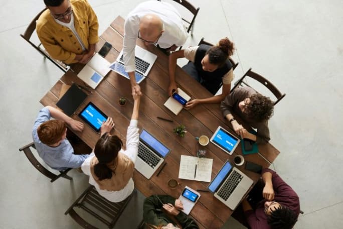 Overhead photo of a team of office workers at a conference table