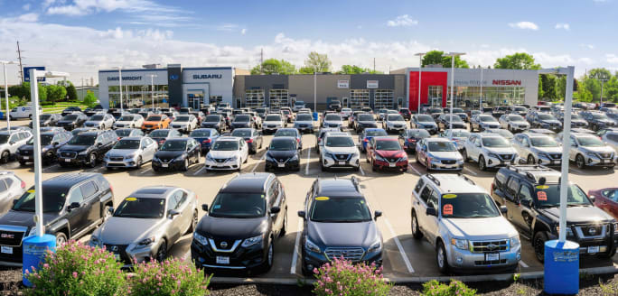 Photo of a new-vehicle sales lot under a sunny sky