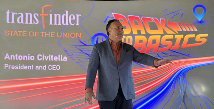 a man stands on a stage delivering a state of the union address to employees