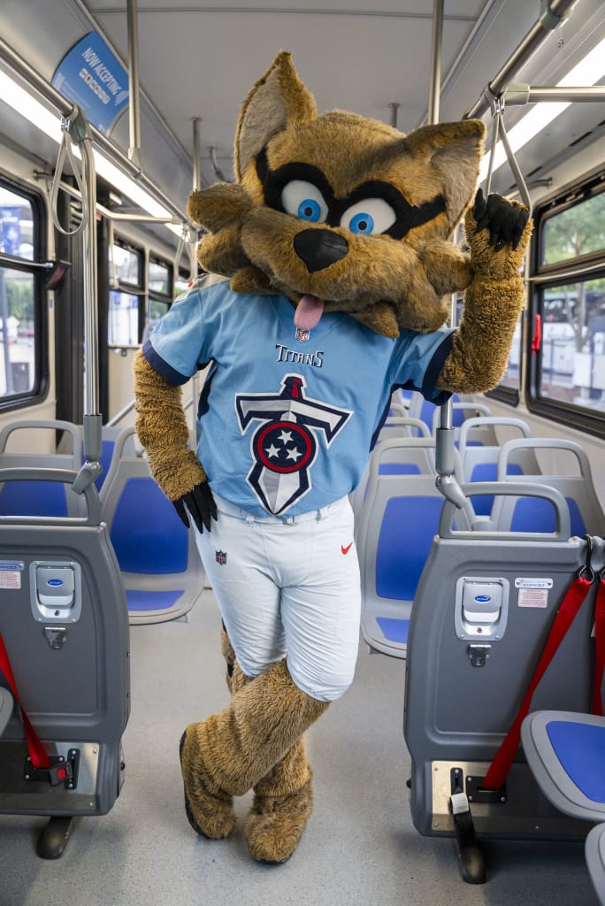 The Tennessee Titans' mascot, T-RAC, poses on a public transit bus.