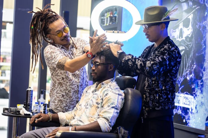 Two hairdressers work on a client