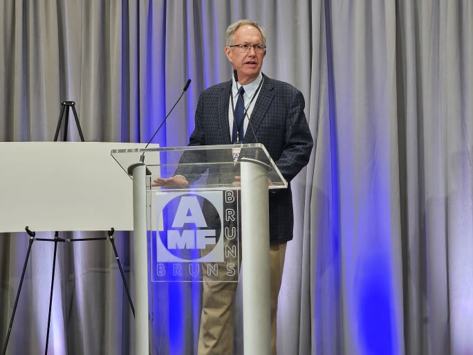 the mayor of stow ohio stands at a podium at a gran opening