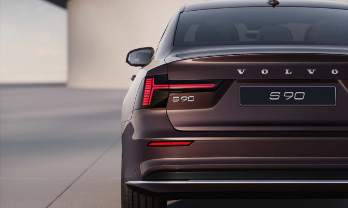 Rear exterior of a maroon Volvo S90.