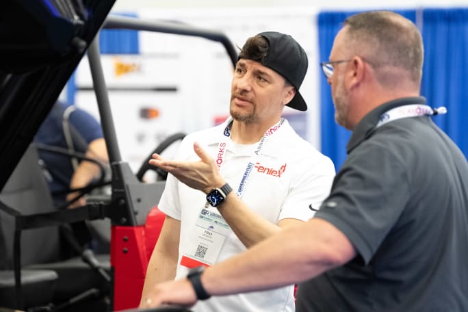 A supplier speaks with an attendee in the exhibit hall.