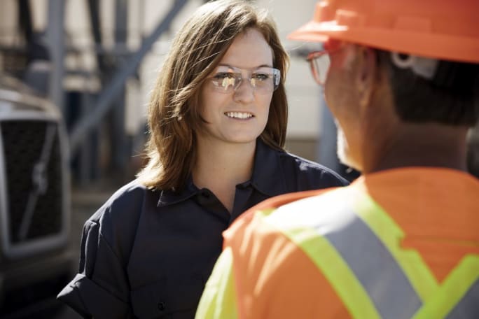 Woman truck driver talking to a worker.
