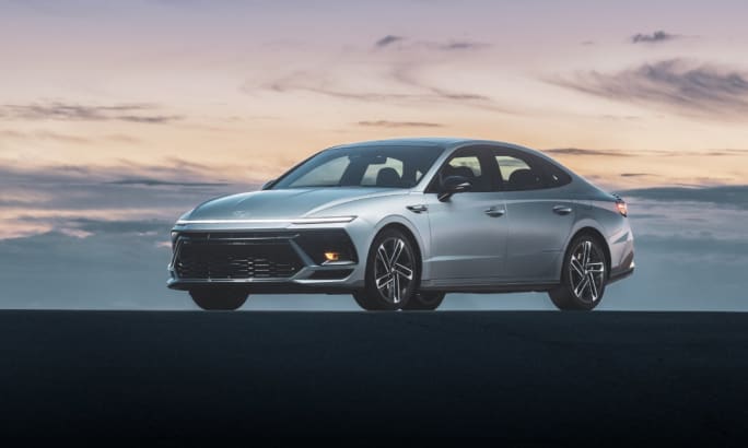A silver 2025 Hyundai Sonata parked in front of a cloudy sunset.