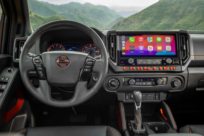 Steering wheel, dashboard, and infotainment system inside a Nissan Frontier.