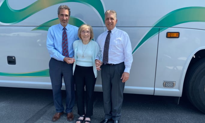 James, Camille, and Thomas Jebran pose in front of a Trans-Bridge Lines motorcoach bus.