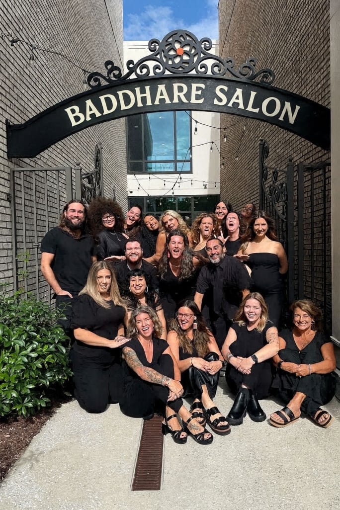 Salon team gathered outside Baddhare Salon entrance, reflecting a strong brand identity and team-led approach to client loyalty and community building.