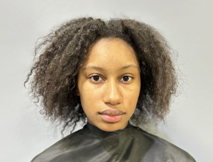 A woman with dark, curly hair