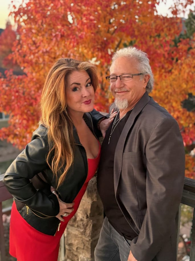 Posing in front of a colorful fall tree, Ame and Dennis Metcalfe, owners of D'Ametris in Broomfield, Colorado.
